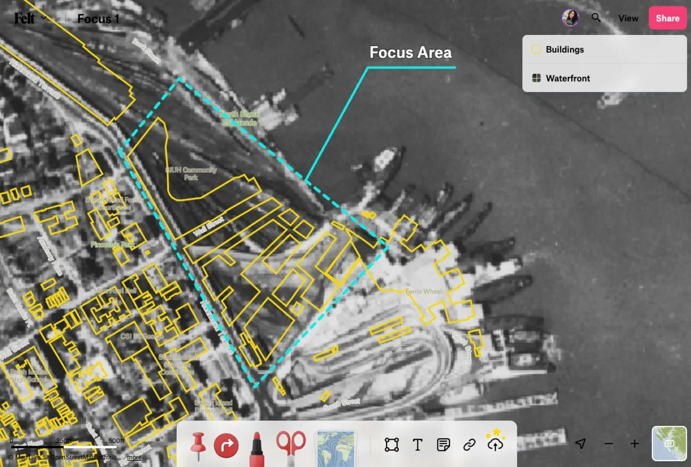 A Felt map over black and white aerial imagery with yellow building outlines and a dashed focus area on a waterfront