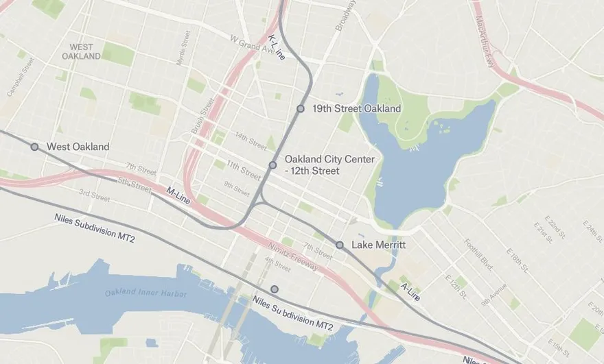 The same area of downtown Oakland rendered as vector tiles, with sharp station labels and rail lines